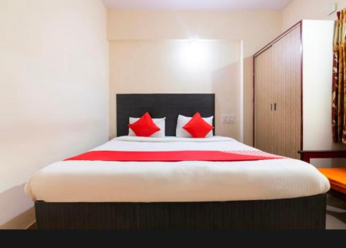 a bedroom with a large bed with red pillows at Royal Guest Inn HSR Layout in Bengaluru