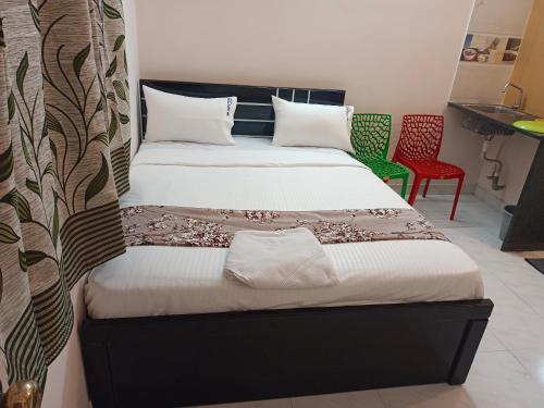 1 dormitorio con 2 camas y silla roja en Royal Guest Inn HSR Layout en Bangalore