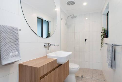 a bathroom with a sink and a toilet and a mirror at Modern Central China town Home - Free Carpark in Adelaide