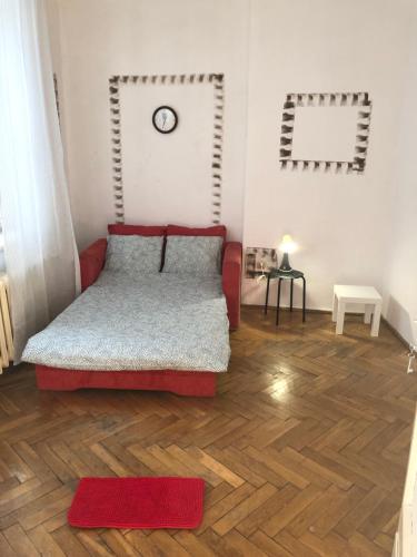 - une chambre avec un lit rouge et du parquet dans l'établissement Pokój 11C, à Cracovie