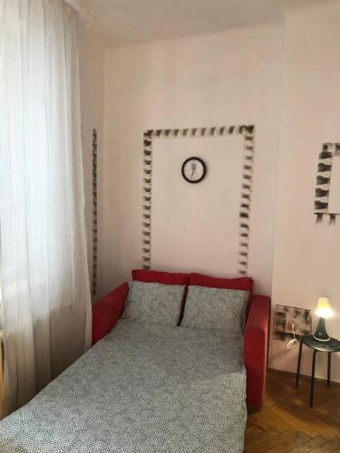 - une chambre avec un lit et une horloge murale dans l'établissement Pokój 11C, à Cracovie