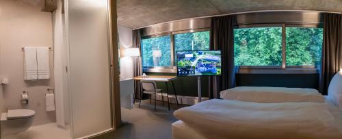 ムルテンにあるCentre Loewenbergのベッド2台とテレビが備わるホテルルームです。
