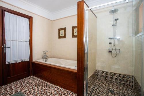 y baño con bañera y ducha. en Casa Lola Lanzarote piscina climatizada y wifi free, en San Bartolomé