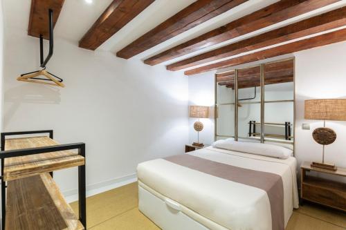 una camera bianca con letto e scrivania di AmazINN Places Gran Via Loft a Madrid