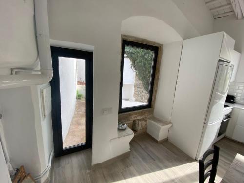 Habitación con 2 ventanas grandes y cocina. en Costa Maresme, Barcelona ,Valentinos House & Pool, en Vilassar de Dalt