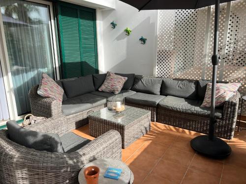 a living room with a couch and chairs and an umbrella at Vila Sol, Apartment 468 in Quarteira