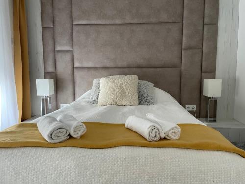 sypialnia z łóżkiem z ręcznikami w obiekcie Quelle-Apartman w Győr