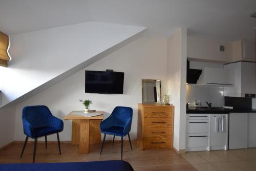 eine Küche mit zwei blauen Stühlen und einem kleinen Tisch in der Unterkunft APARTAMENTY TR 11 Apartament nr 5 in Olsztyn