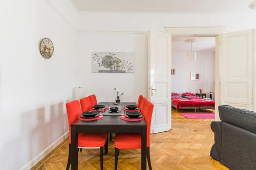 ブダペストにあるFriendly Apartment Oktogonのダイニングルーム(黒いテーブル、オレンジの椅子付)