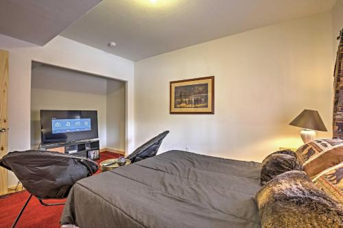 a bedroom with a bed and a flat screen tv at Expansive Alma Cabin with Hot Tub and Mountain Views! in Alma
