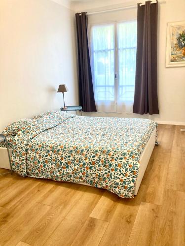 une chambre avec un lit avec un couvre-lit fleuri dans l'établissement Maison otto, à Menton