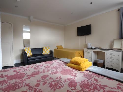 a bedroom with a bed and a couch and a desk at The Shoulder at Hardstoft in Hardstoft