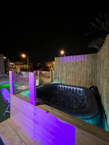een hot tub met paarse verlichting in een achtertuin 's nachts bij דירה מרהיבה עם ג׳קוזי in Eilat