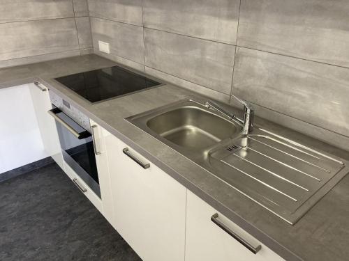 cocina con fregadero de acero inoxidable y fogones en Ferienwohnung Alte Münz, en Müllheim