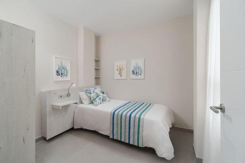a white bedroom with a bed and a sink at Las Afortunadas , Playa Arinaga 1ºA in Arinaga