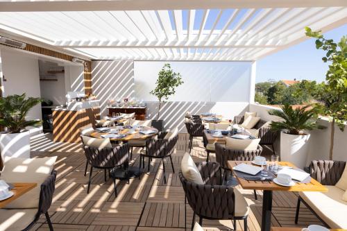 restauracja ze stołami i krzesłami na patio w obiekcie Victoria Boutique Hotel w Arcachon