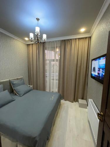 - une chambre avec un lit et une télévision à écran plat dans l'établissement Apartments in the center of Gyumri, à Gyumri