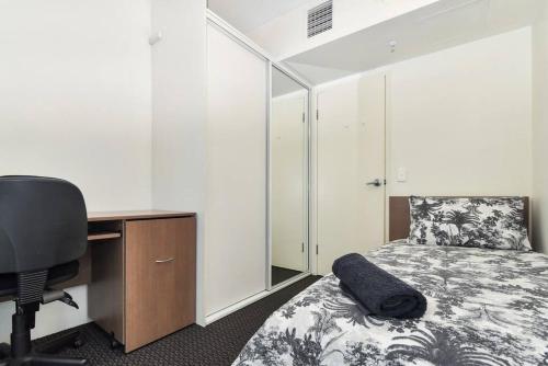a bedroom with a desk and a bed and a chair at Light & Airy 3 Bd CBD Apt: BalconyTramWifi/Parking in Adelaide