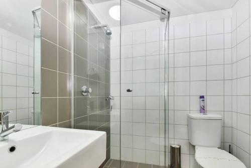 a bathroom with a shower and a toilet and a sink at Light & Airy 3 Bd CBD Apt: BalconyTramWifi/Parking in Adelaide