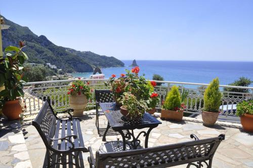a patio with a table and chairs and the ocean at Mazis Apartments in Agios Gordios