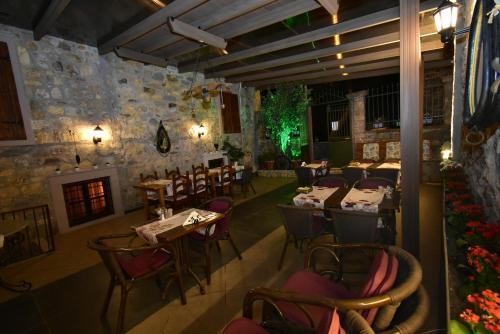 ein Restaurant mit Tischen und Stühlen und einem Kamin in der Unterkunft Olivia1845 Guest House Ayvalık in Ayvalık