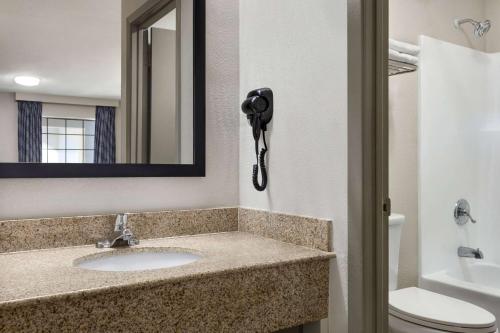 a bathroom with a sink and a mirror and a toilet at Days Inn by Wyndham Fulton in Fulton