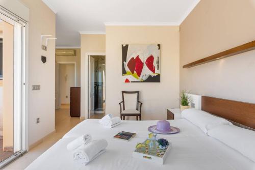 um quarto com uma grande cama branca e uma mesa em Villa Blasco - PlusHolidays em Calpe