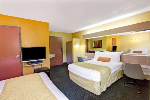 a hotel room with two beds and a flat screen tv at Microtel Inn & Suites by Wyndham Gatlinburg in Gatlinburg