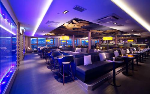 a restaurant with blue lighting and tables and chairs at Radisson Blu Latvija Conference & Spa Hotel, Riga in Rīga