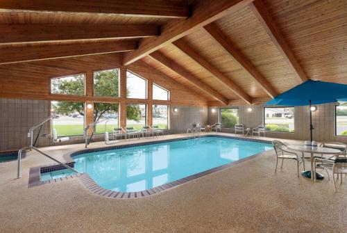 a large swimming pool with a table and chairs at AmericInn by Wyndham Bemidji in Bemidji