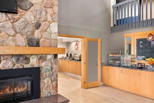 a fireplace in a room with a stone wall at AmericInn by Wyndham Bemidji in Bemidji