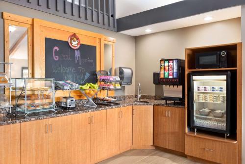 a restaurant kitchen with a counter with a refrigerator at AmericInn by Wyndham Bemidji in Bemidji