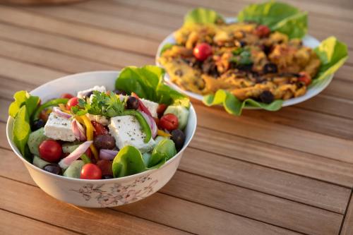 a bowl of salad and a plate of food on a table at Naxian green life in Agia Anna Naxos