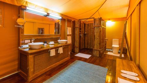 a bathroom with two sinks and a mirror at Bagh Villas I Kanha in Kānha