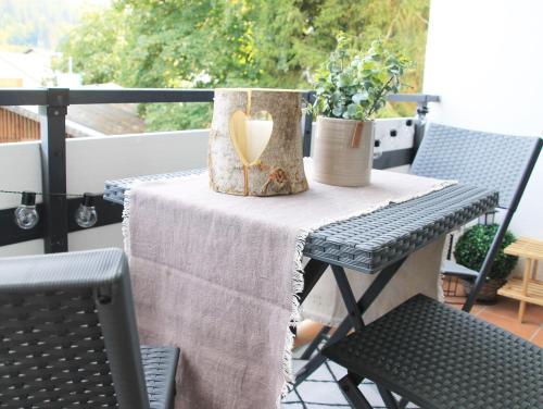 a table on a balcony with a heart decoration on it at Ferienwohnung-Sonnenblick-Willingen in Willingen