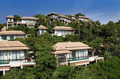 a group of houses on a hill with trees at Banyan Tree Samui in Lamai