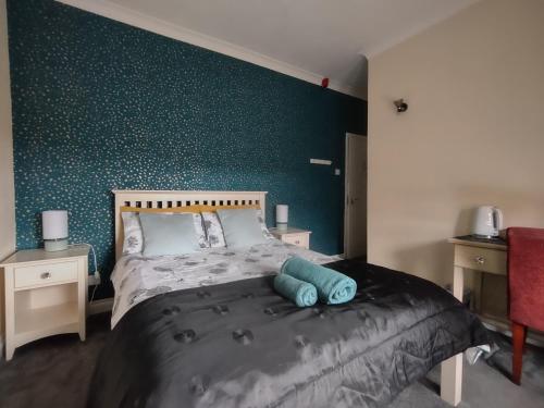 a bedroom with a bed with a green wall at The Shoulder at Hardstoft in Hardstoft