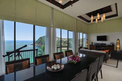 a living room with a table and a view of the ocean at Banyan Tree Samui in Lamai