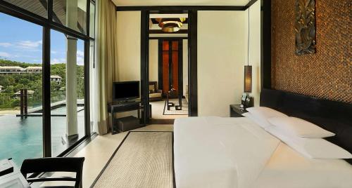a bedroom with a bed and a view of a pool at Banyan Tree Samui in Lamai