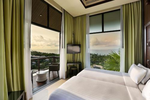 a bedroom with a bed and a balcony at Banyan Tree Samui in Lamai