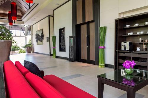 a living room with a red couch and a table at Banyan Tree Samui in Lamai