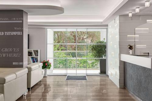 a living room with a large window and a couch at TRYP by Wyndham Corfu Dassia in Dassia