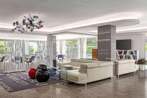 a living room with two couches and a tv at TRYP by Wyndham Corfu Dassia in Dassia