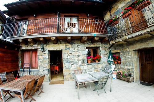 a patio with a table and chairs and a balcony at Balcon del Pirineo Rural Ordesa in Buesa