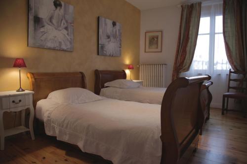 una camera d'albergo con due letti e una finestra di Le Square a Bourg-Argental