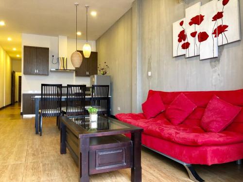 a living room with a red couch and a table at Asiban Quay Boutique Hotel in Phnom Penh