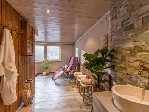 baño con pared de piedra y lavamanos en Hotel Kössler, en Tux