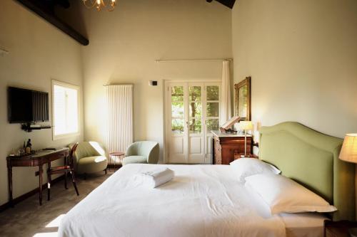 a bedroom with a large white bed and a desk at Residenza San Vito in Calamandrana