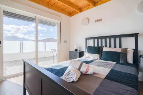 ein Schlafzimmer mit großem Bett und Blick auf das Meer in der Unterkunft Villa Adrián in Las Palmas de Gran Canaria