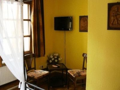 a living room with two chairs and a tv on the wall at Hotel Restaurant Zum Alten Ritter in Bad Bodenteich